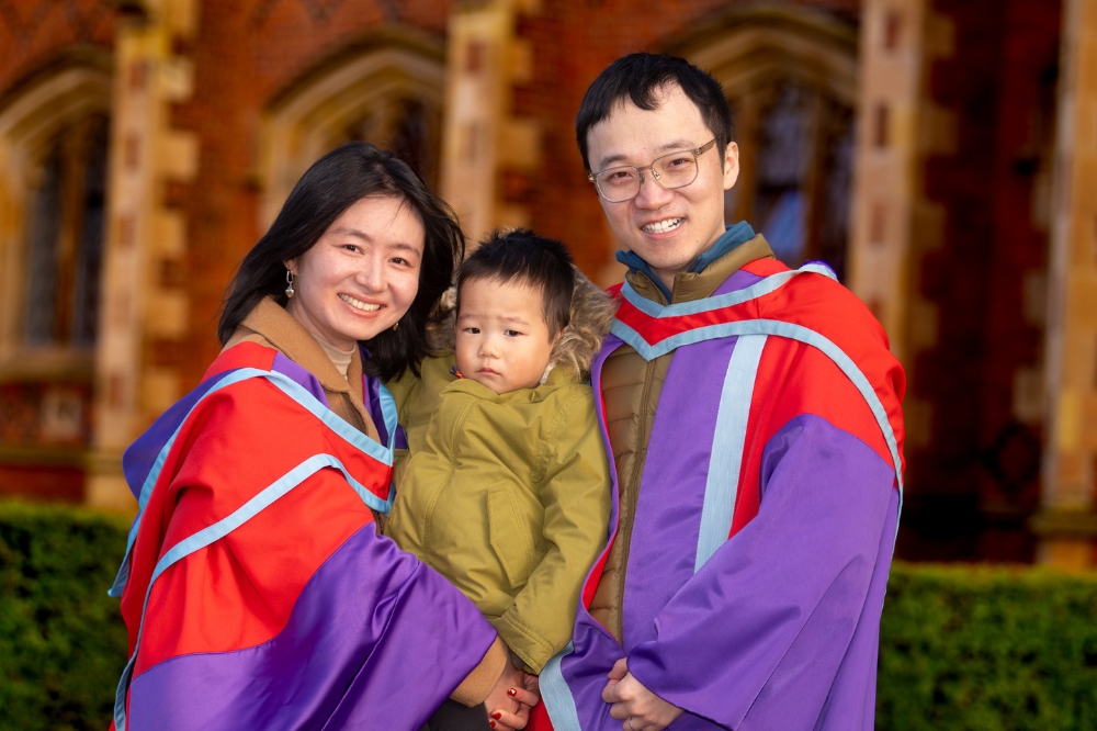 two new International doctoral graduates celebrate with their son