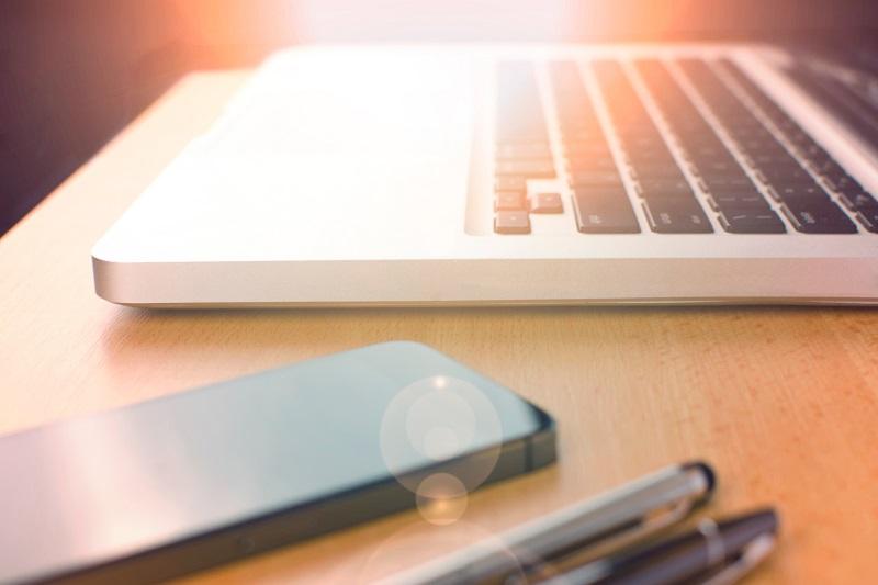 laptop, phone and writing pens