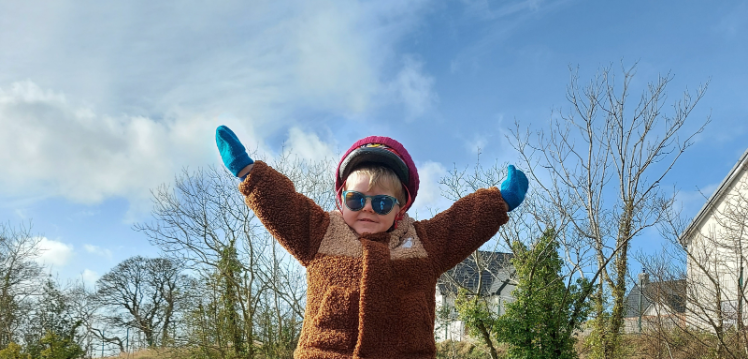 Charlie Scott wearing sunglasses with arms in the air