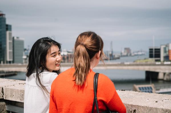 two female students chatting in Belfast on a bridge