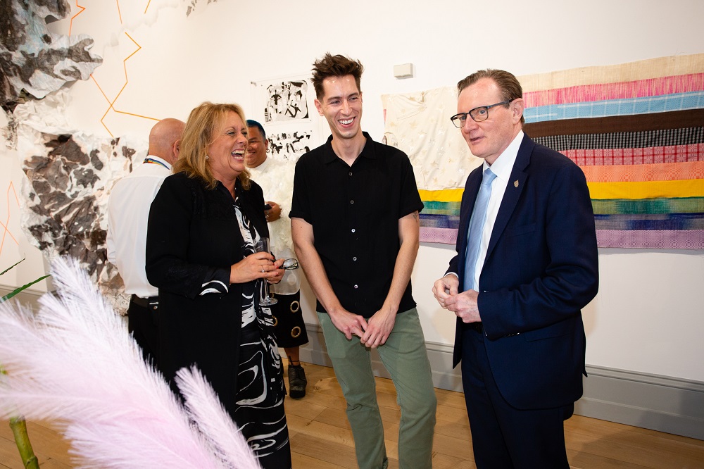 Anne McLaughlin, Ben Crothers and Vice-Chancellor Ian Greer enjoying the Naughton Gallery's 20th anniversary exhibition