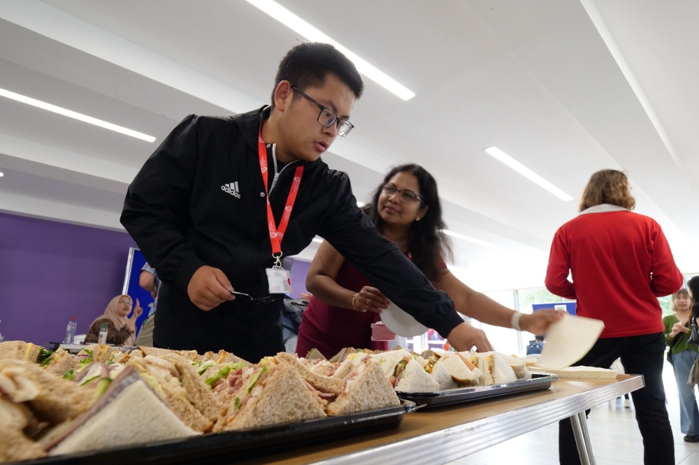 Staff helping themselves to sandwiches at the Language Centre / iRise Summer Social and Wellbeing event, Peter Froggatt Centre