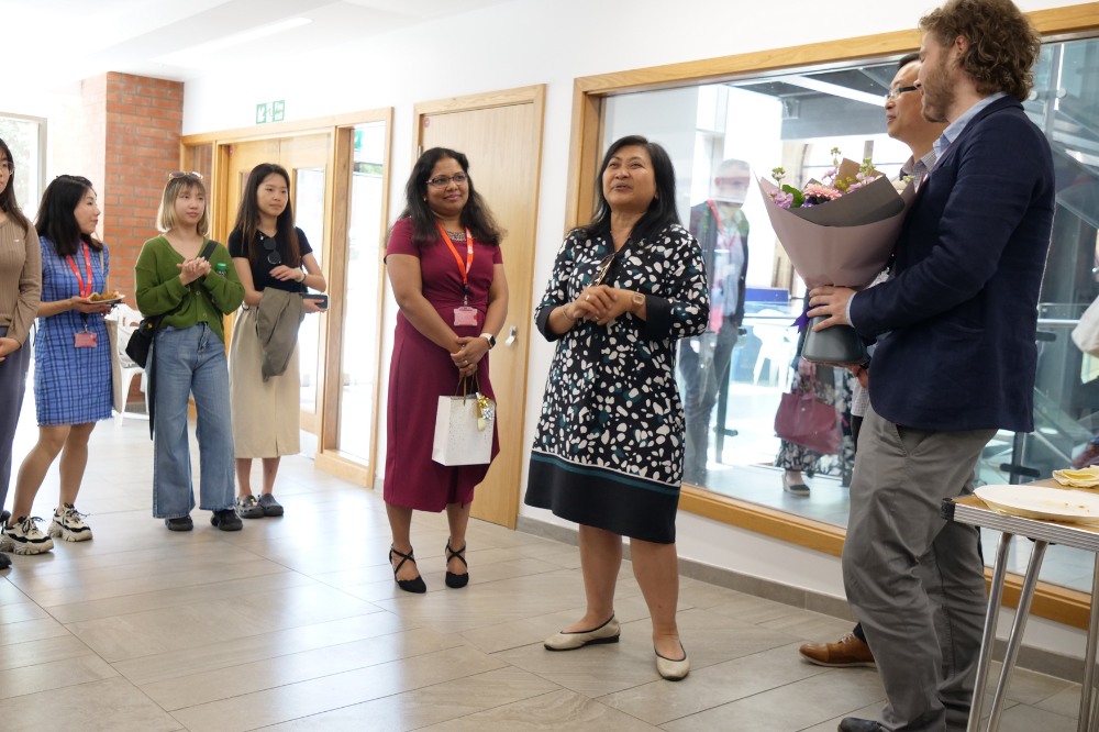 Language Centre and iRise staff members chatting and presenting flowers at the Language Centre / iRise Summer Social and Wellbeing event, Peter Froggatt Centre