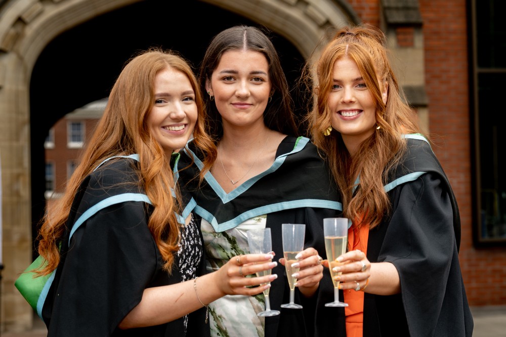 three female graduates celebrating with sparkling refreshment