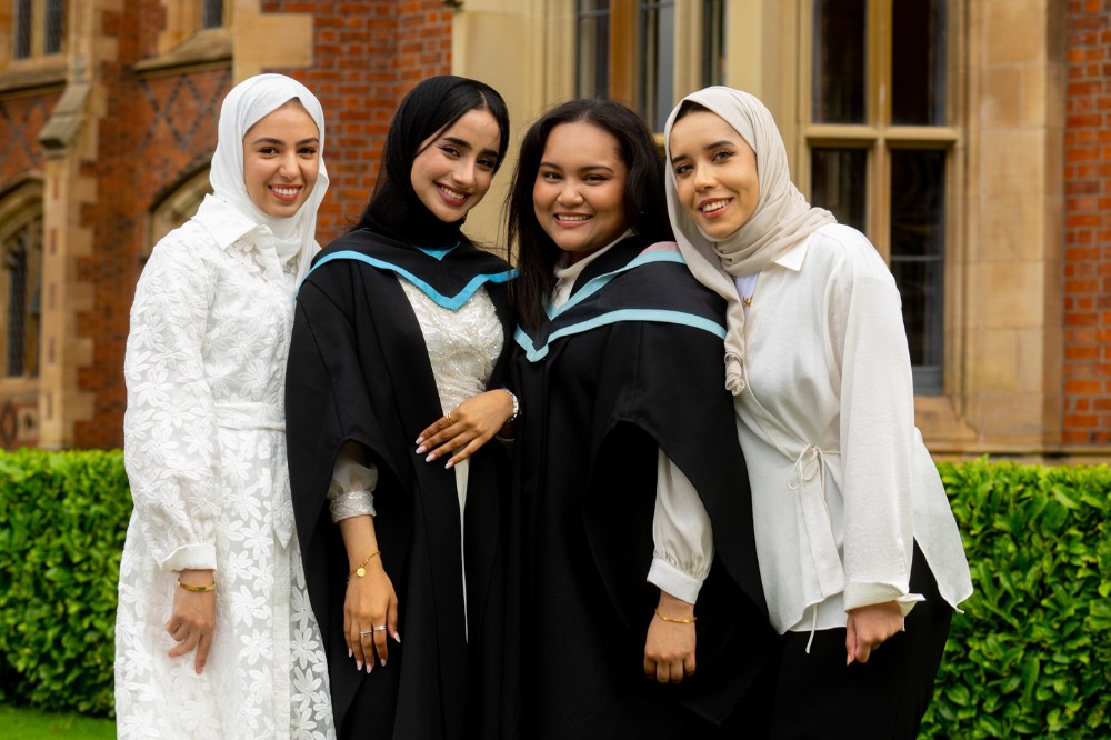 International female graduates posing with friends
