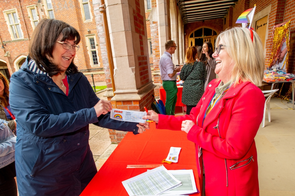staff member picking up her ticket at QUB Pride Picnic 2023