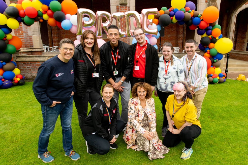 group shot of staff posing in front of the Pride balloon arch at QUB Pride Picnic 2023