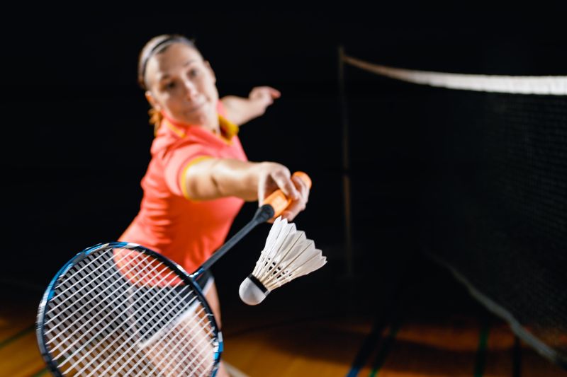 close-up of woman about to hit a shuttlecock with her badminton racquet