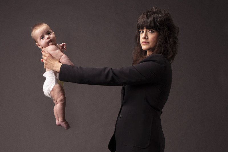 self-portrait-style photographic item entitled 'Holding My Child at Arms Length', from artist Sarah Maple's art exhibition 'Call Me Mother', showing the artist holding her baby at arms length