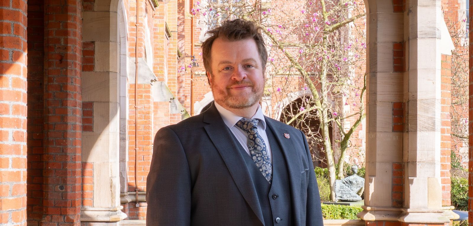 Man standing in the cloisters of Queen's University Belfast